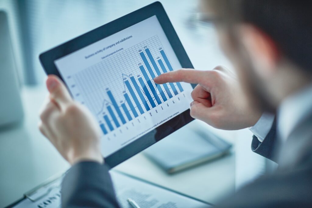 A person pointing at a bar chart on a tablet screen, representing SEO performance analysis for SEO services in Charlotte.