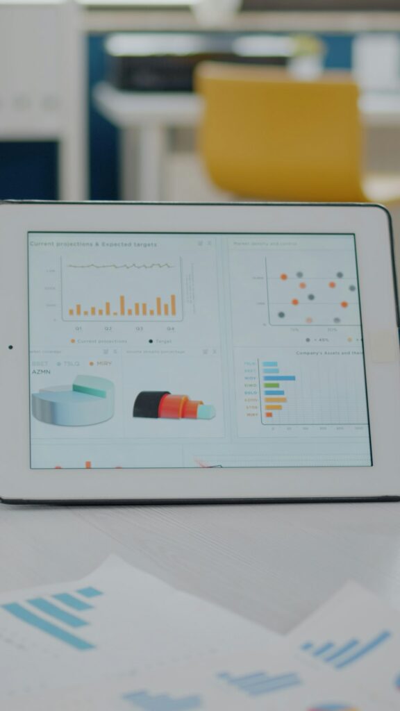 Close up of tablet and papers with data charts on desk