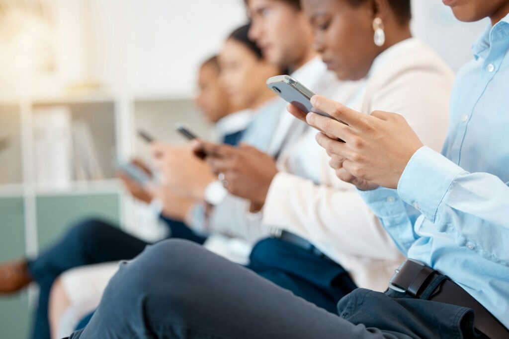 A group of people, focused on their smartphones, representing the diverse clientele accessing SEO services in Dallas.