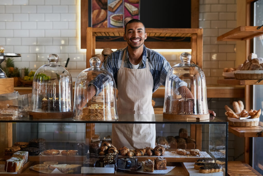 Small business owner standing behind the bakery counter.