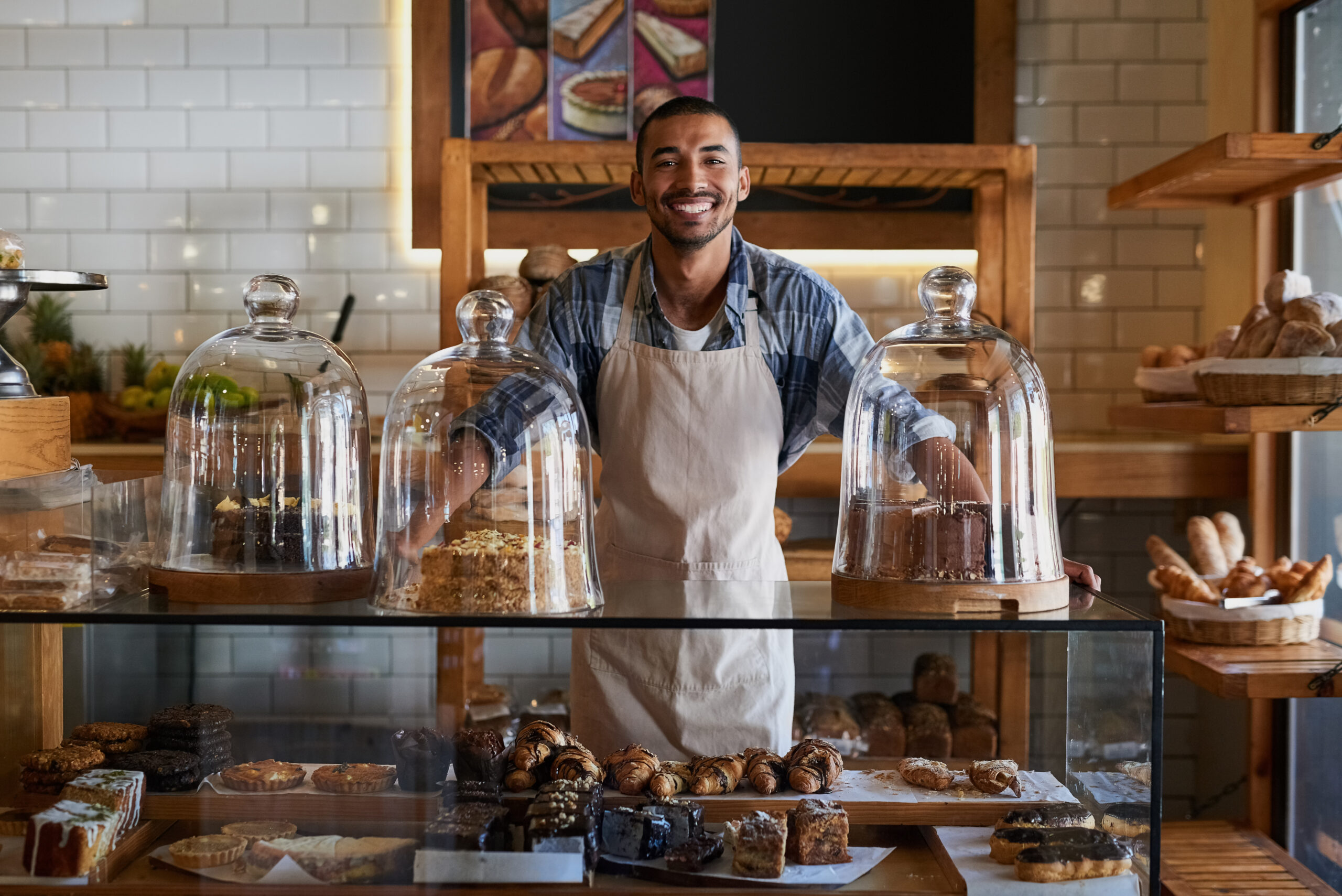 Small business owner standing behind the bakery counter.