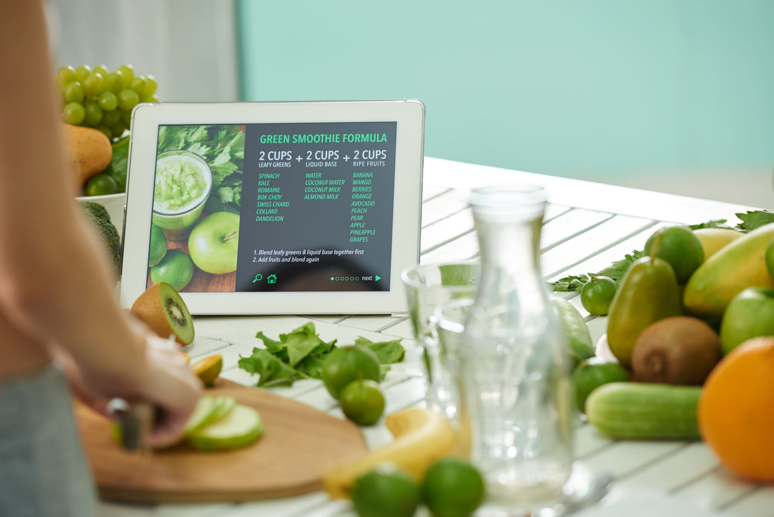 A tablet displaying a green smoothie recipe on a kitchen table, symbolizing the process of refreshing content, similar to a website redesign.