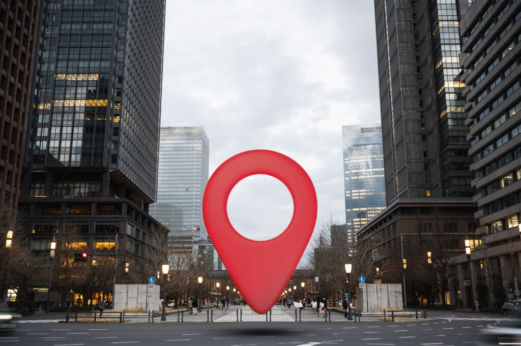 Red location pin placed in the middle of a cityscape, representing Local SEO.