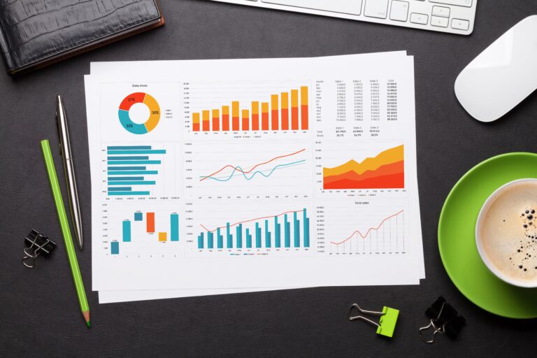 A desk with charts and graphs representing website analytics, highlighting the importance of data in a website redesign.