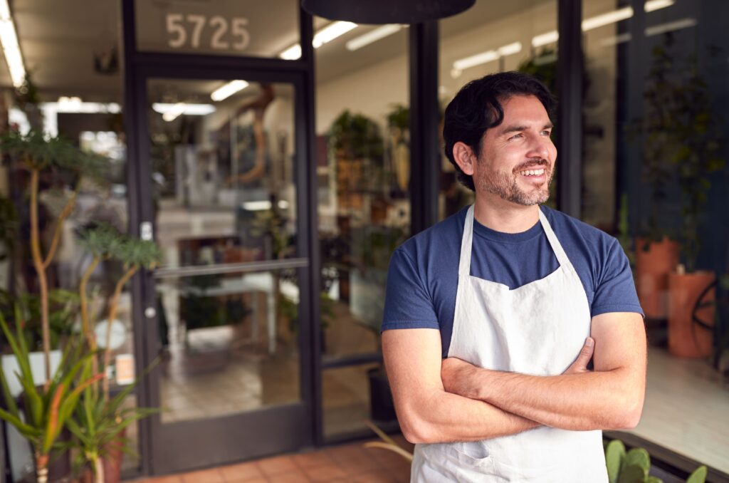 Local business owner standing confidently outside his store.