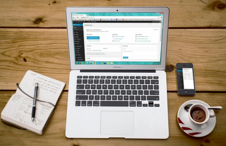 A MacBook Air displaying a WordPress dashboard on a wooden desk, illustrating the technical setup required for Blogging for SEO and content management.